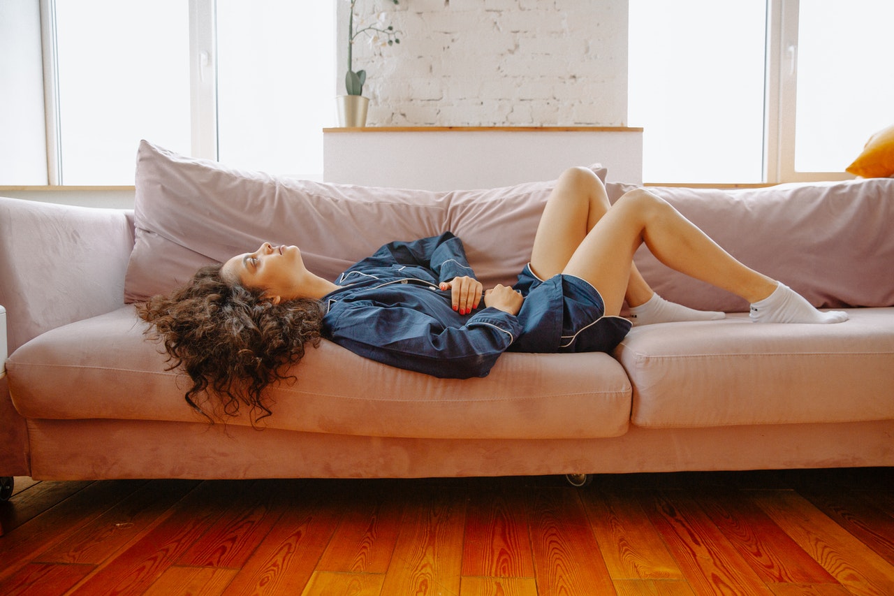 woman on couch holding her stomach